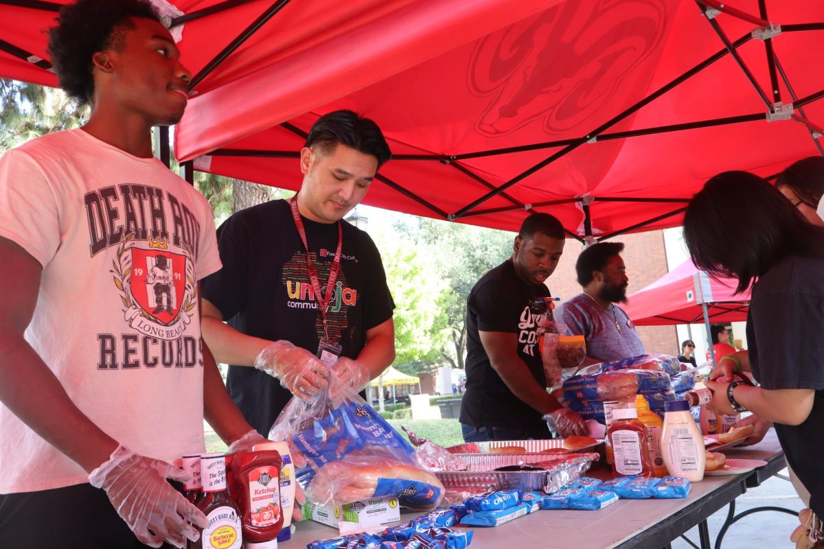 Devontay Sanders, Peter Vang, Davion Baker and Martin Herb serve food while Rosie Thao grabs a plate at the Fresno City College Veterans Square on Sept. 17.