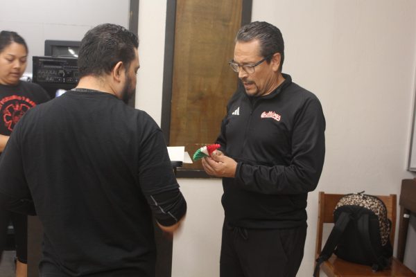 Victor Torres shows Artemio Quintana how to create a prop for one of their dances during their class on Oct. 13.