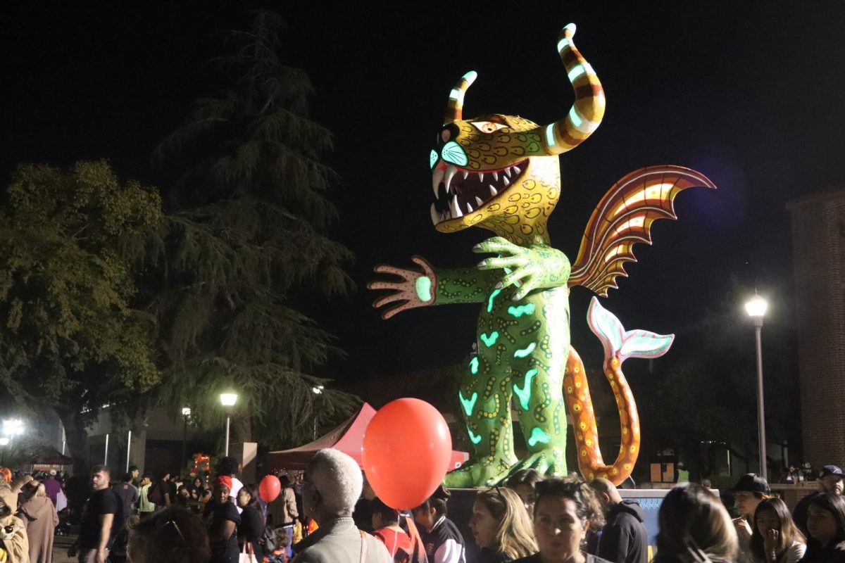 An alebrije from Arte Americas is perched above the 2025 Fresno City College Fall Carnival outside the library on Oct. 24, 2025.