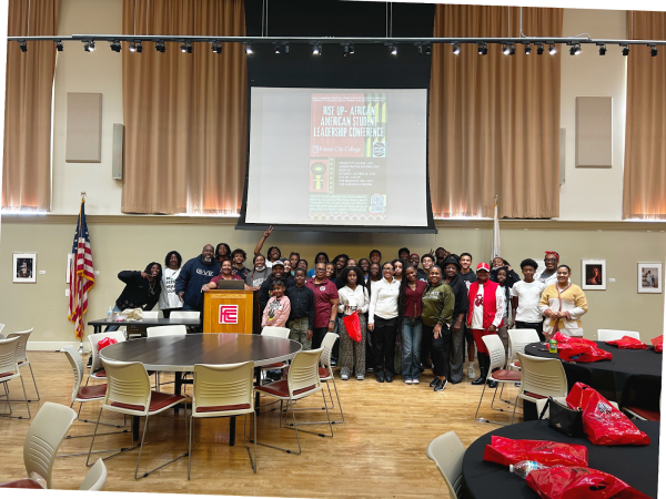 BAPAC, Umoja Community, Fresno and Clovis Unified School District students pose for a picture underneath a projector that displays the “Rise Up” conference flyer at Fresno City College in the Old Administration Building on Oct. 25.