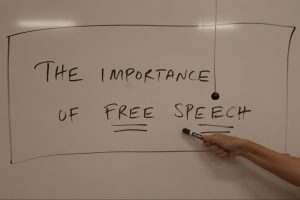 Professor Barri Brennan poses and gestures to a whiteboard with the phrase "the importance of free speech" in one of her Fresno City College classes. This is a staged photo and not a part of Brennan's lecture.