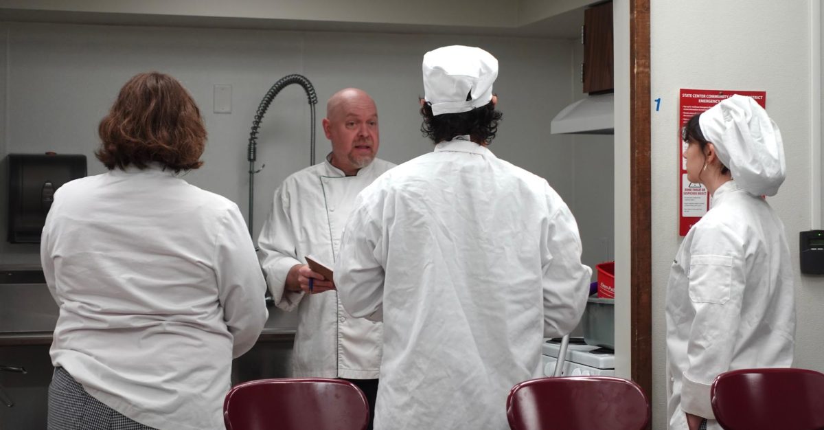 Chef Jonathan Davey speaks to three culinary arts students before their final exam in FN-1 Food Preparation in the Art/Home Economics building, Oct. 9, 2025.