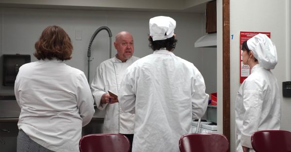 Chef Jonathan Davey speaks to three culinary arts students before their final exam in FN-1 Food Preparation in the Art/Home Economics building, Oct. 9, 2025.