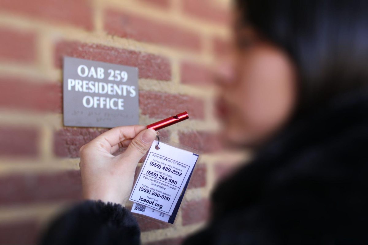 A photo of a student by the Fresno City College president's office holding a whistle provided by the Social Justice Center to be used if ICE is spotted on campus.