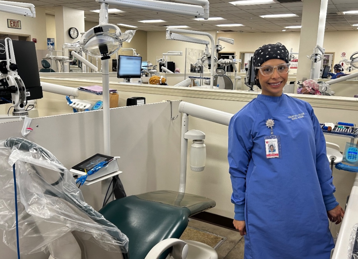 Naomi Jackson stands for a picture in the dental hygiene clinic at Fresno City College on March 3. One computer screen is blurred in the background for patient privacy.